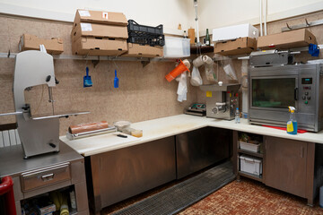 Professional butcher slicing meat in well-organized macelleria with tools and equipment