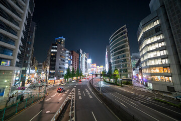 Tokyo, Japan - April 26, 2025: Shinjuku district at night with glowing signs, high-rise buildings, and busy pedestrian traffic