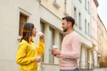 Coffee to go. Couple with paper cups of drinks on city street