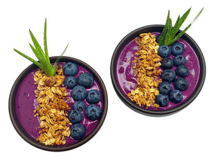 Two purple smoothie bowls topped with blueberries and granola