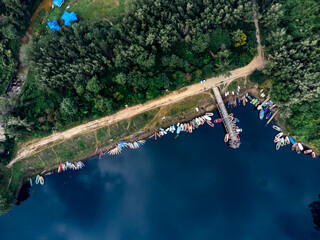 Mohamaya Lake is the second-largest artificial lake in Bangladesh, located in Mirsarai, Chittagong, Bangladesh. Aerial view of a tranquil lake with a pier and docked boats surrounded by lush greenery.