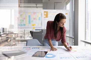 Businesswoman working with papers in modern high-rise building office