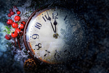 A vintage clock decorated with red berries and pine branches is covered in frost and snow, showing midnight as a festive symbol of New Year Eve celebration.