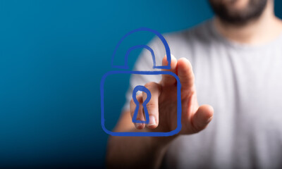 A person's hand interacts with a blue digital padlock icon, symbolizing cybersecurity, data protection, and secure access in a modern digital wo