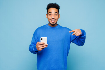 Young man of African American ethnicity wear sweatshirt casual clothes hold in hand use point...