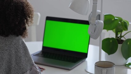 Primary school Student African American child with headphones using laptop green screen chroma key. Distance learning online education. Schoolboy girl studying at home with digital tablet computer and