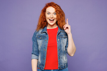 Young shocked surprised proactive ginger woman she wears red t-shirt denim shirt holding index...