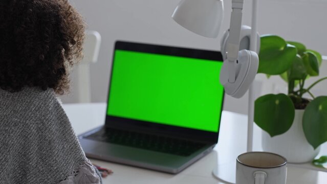 Primary school Student African American child with headphones using laptop green screen chroma key. Distance learning online education. Schoolboy girl studying at home with digital tablet computer and