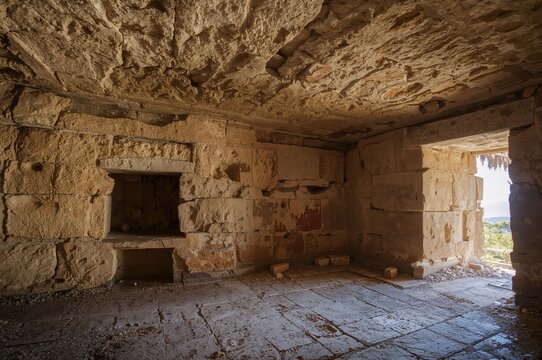 Inside the ancient stone tholos chamber with natural light filtering through the entrance