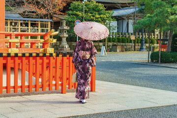 Japanese woman wearing traditional kimono clothes and holding umbrella at shrine in Kyoto. Japan