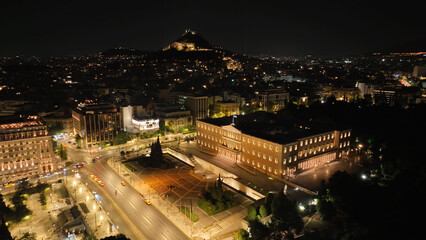 Aerial drone night shot from famous illuminated Syntagma square and Greek Parliament  building, Athens historic centre, Attica, Greece