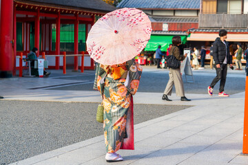 Japanese woman wearing traditional kimono clothes and holding umbrella at shrine in Kyoto. Japan