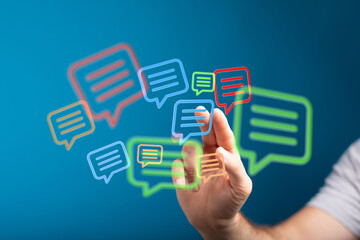 Person interacts with digital speech bubbles, representing modern communication and social media interactions online.