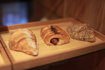 Freshly baked croissants on a wooden tray