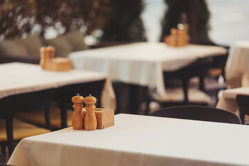 Enjoying a peaceful moment at a cozy outdoor dining area with wooden decor and elegant tables under soft lighting in the evening