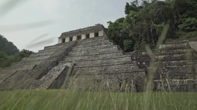 Cinematic clip capturing the weathered grandeur and imposing scale of one of Palenque's primary stepped pyramids, the Temple of the Inscriptions.