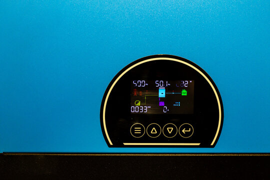 Close-up of a bright blue solar power inverter's digital display, showing real-time system metrics, symbolizing advanced technology for efficient energy monitoring and sustainable power.

