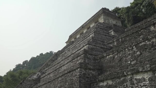 A slow-motion clip capturing the weathered grandeur and imposing scale of one of Palenque's primary stepped pyramids, the Temple of the Inscriptions.