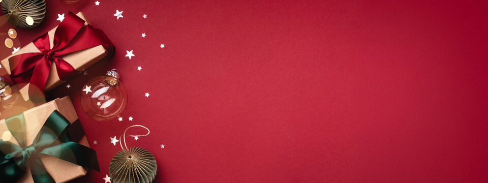Banner with two gift boxes and Christmas ornaments on red background. Boxing day, Christmas and New Year gifts.
