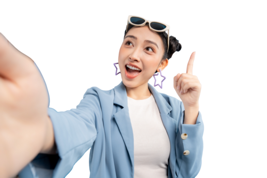 Young Asian woman taking a selfie with an excited expression, pointing upwards, with glasses - Powered by Adobe