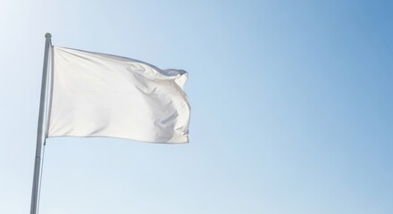 Fototapeta premium White flag waving in light blue sky. Symbol of peace and surrender. Blank flag for custom design.