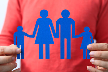 Person holding a paper cutout of a family, symbolising family, love, support, and togetherness....