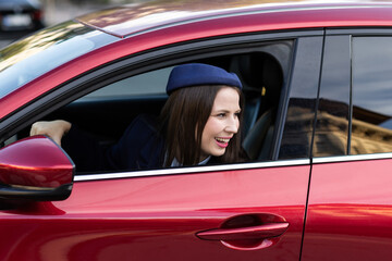 Attractive young female driver in casual outfit, driving car, road safety and transportation theme.Young woman driving car. Travel concept.
