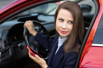 Attractive young female driver in casual outfit, driving car, road safety and transportation theme.Young woman driving car. Travel concept.