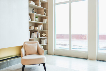 Stylish loft living room interior. Spacious design apartment with light white walls large window beige chair armchair. Clean modern decoration with elegant furniture in minimalist Scandinavian style