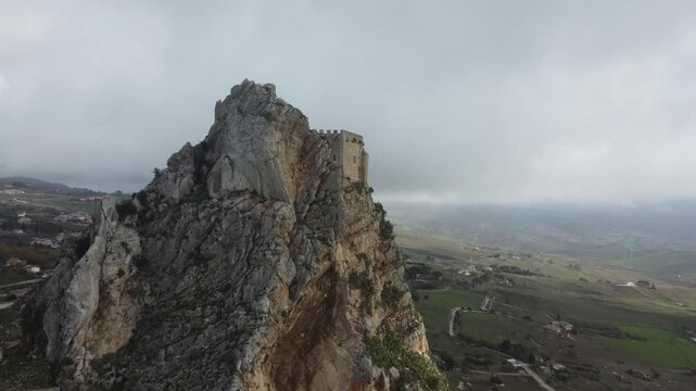 Aerial 4k drone footage of Mussomeli Castle in Sicily, Italy, featuring the historic fortress, dramatic misty atmosphere, surrounding hills, and panoramic views of the landscape