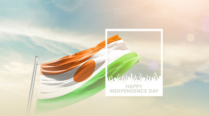 Niger flag waving proudly under a bright sky with text happy independence day. Niger national flag for independence day.