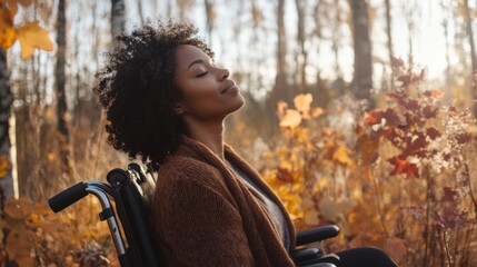 A woman in a wheelchair is sitting in a field of leaves. She is smiling and she is enjoying the moment