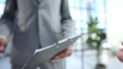 A man is holding a tablet with a black cover - Powered by Adobe