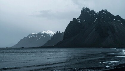 Dark, dramatic coastal mountains meet a moody sea
