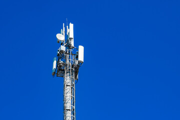 mobile communication and wireless internet 5g  antennas on mast against blue sky