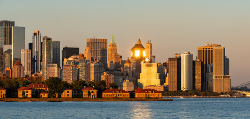 New York City view of Lower Manhattan skyline at sunset with Financial District skyscrapers. Ellis...