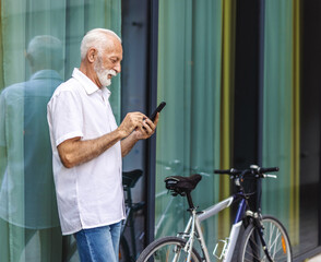Bicycle, phone and thinking with business senior man outdoor in city for communication or commute. Building, directions on mobile app and serious mature employee with green transportation for cycling.