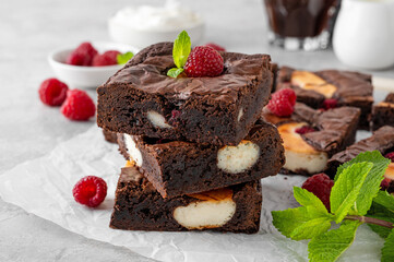 Cheesecake brownies with raspberry on a gray concrete background. Delicious dessert