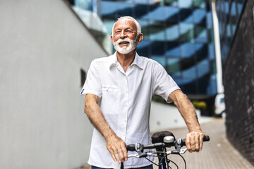 Business, man and walking with e bike in city for sustainable transport, eco friendly and carbon neutral travel. Mature person, bicycle and morning commute, urban journey and daily adventure.