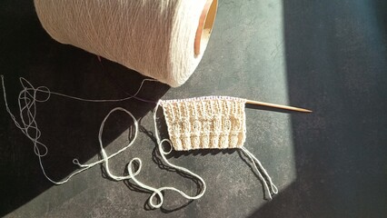 Knitting from white bobbin yarn, needlework, hobby. High quality photo