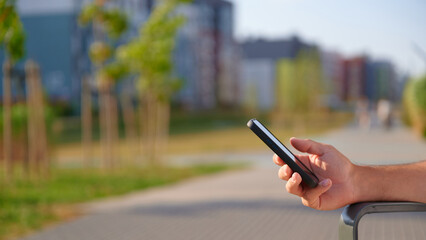 Person holding smartphone outdoors on bench