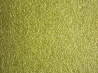 The textured surface is yellow, light green, pistachio color, herbal color as a background. Felt. High quality photo