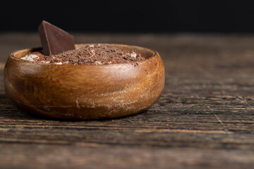yogurt in a wooden bowl with chocolate crumbs, chocolate pieces in milk yogurt, sweet dessert with chocolate