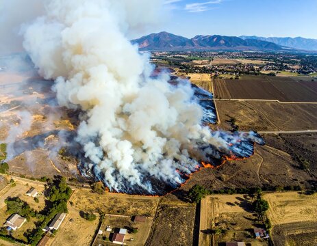 Aerial view of wildfire engulfing rural landscape