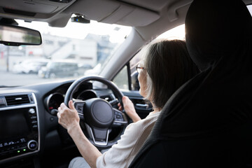 車の運転をする女性の高齢者　顔無しの後ろ姿