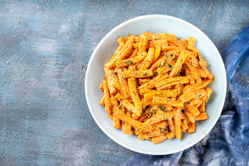 Creamy Pumpkin Pasta. Cozy autumn recipe of casarecce pasta in rich flavorful pumpkin squash cheesy sauce with garlic and aromatic herbs, copy space