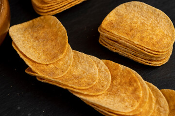 crispy potato chips fried in oil and sprinkled with spices of dried red sweet pepper, a large number of delicious salty sweet pepper-flavored chips with aromatic spices