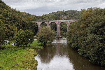 Fototapeta premium Early autumn view of the 19th century 40m high Conques Viaduct as it crosses the Semois River near Herbeumont in the Ardennes Region of Belgium. Copy space below.