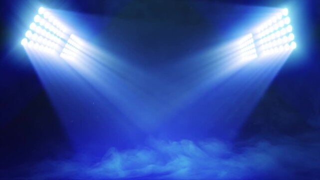 Animated sports graphic background plate, with bright banks of floodlights shining dramatic volumetric light over a misty, atmospheric scene, in deep blue color palette