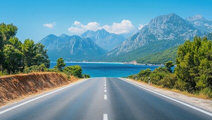 Open road leads towards calm turquoise sea framed by lush green trees and majestic mountains under sky